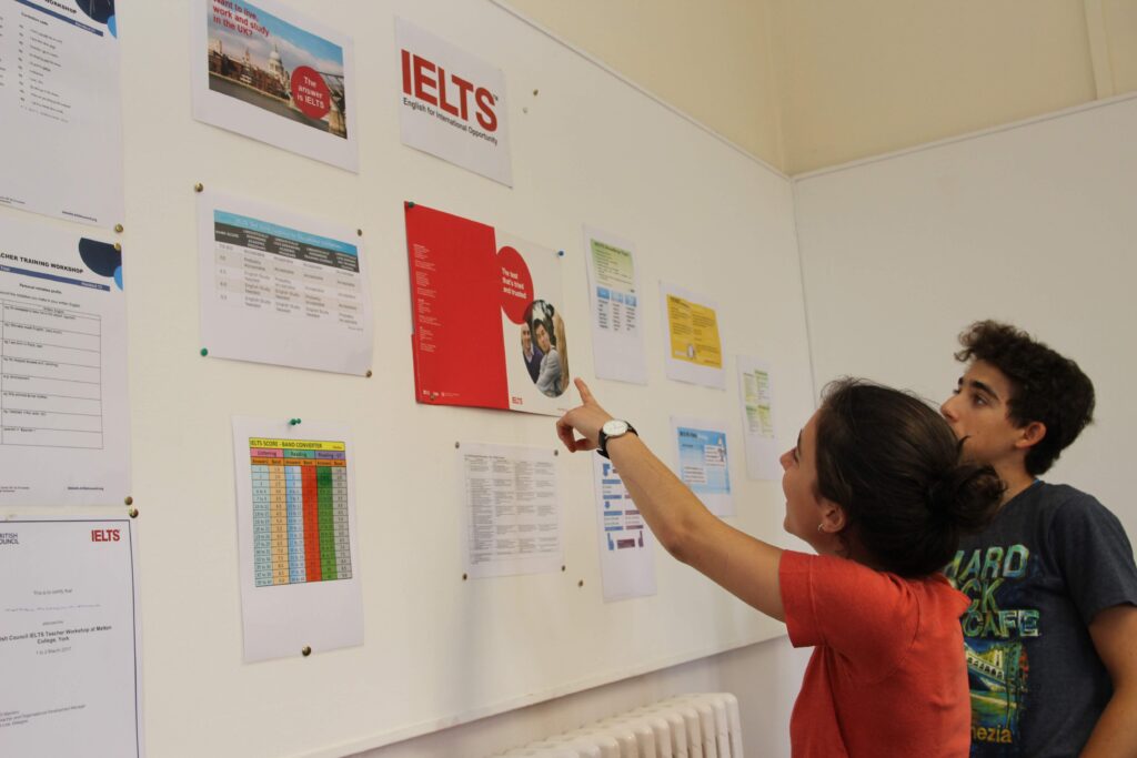 Students looking at noticeboard about IELTS